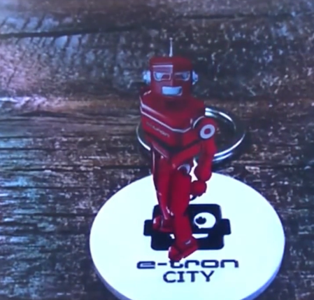 Der auf dem Tisch liegende Schlüsselanhänger eines Audi eTron ist augmentiert mit einem Roboter Avatar in 3D.
