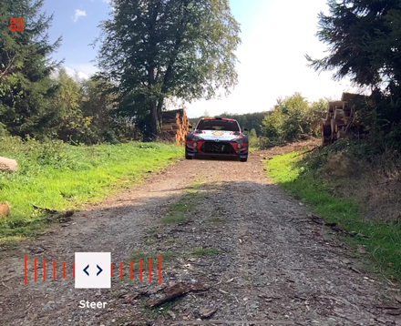 In einem Kamerabild auf einem iPad ist ein Feldweg auf dem auf den Betrachter ein 3D AR Hyundai Rally Car zurast. 